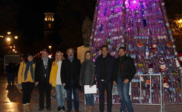 Autoridades y representantes de los centros posan junto al árbol 'reciclado' en la plaza San Juan de la Cruz. /SDC