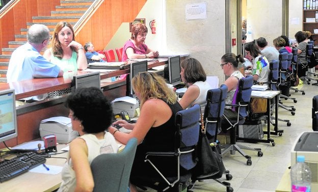 Empleados públicos de la Consejería de Hacienda atienden a varios ciudadanos.