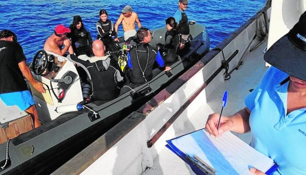 Una inspectora del Servicio de Pesca y Acuicultura de la Comunidad Autónoma, durante un control a una lancha de buceadores.
