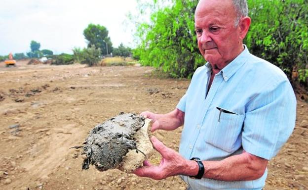 Ramón Illán sostiene en un tormo el lodo aún blando que ha depositado la CHS en una antigua curva del río.