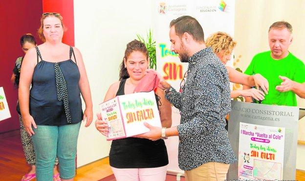 David Martínez entrega el material de la I Marcha 'Vuelta al cole', a una maestra.