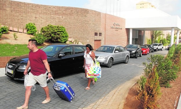 Dos turistas salen del Hotel Roc Doblemar, este verano.
