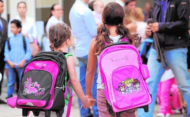 Dos niñas con sus mochilas escolares en su primer día de clase.