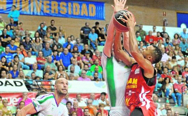 Un jugador del Unicaja defiende una entrada a canasta de Clevin Hannah./Nacho García / AGM