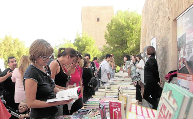 Visitantes ojean, ayer, algunos de los ejemplares que se ofrecían en grandes mesas./Sonia M. Lario / AGM
