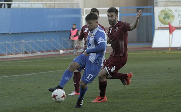 El 'loco' Alonso maneja el balón ante la presión de dos jugadores del Badajoz./Sonia M. Lario / AGM