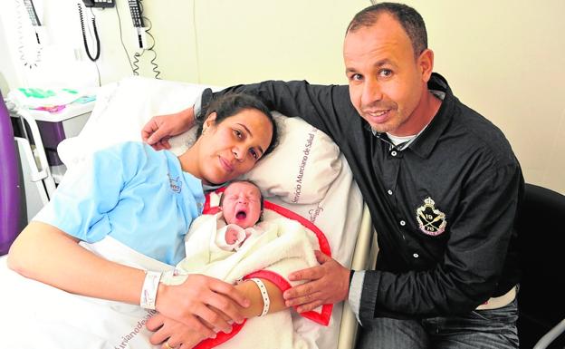 Nassim bosteza arropado por sus padres, Samira y Rachid, ayer en La Arrixaca./V. Vicéns / AGM