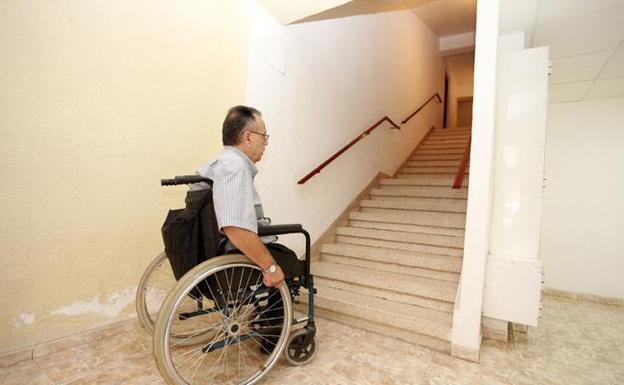Imagen de archivo de un discapacitado mostrando la dificultad de subir las escaleras de su edificio. /F. Manzanera/ AGM