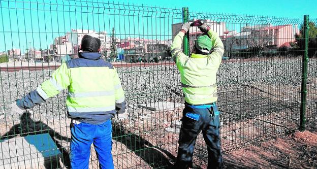 Operarios, ayer, instalando el vallado para evitar que los estudiantes crucen las vías por Las Tejeras./Badía