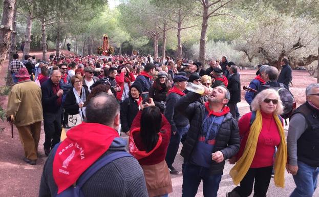 Una vecina de espaldas, móvil en mano, para inmortalizar a La Santa y a miles de devotos./P. Espadas