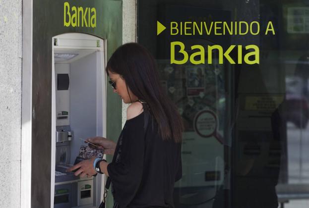Una mujer usa un cajero de Bankia. /Sergio Perez / Reuters