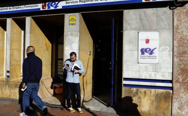 Un hombre consulta su teléfono a las puertas de la oficina del SEF en Ronda Norte de Murcia. /Edu Botella / AGM