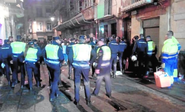 La Policía despeja la calle del Aire, al lado de las brigadas de limpieza, la madrugada del Viernes Santo./LV