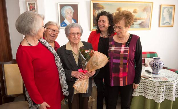 Concepción Lax, con un ramo de rosas, rodeada de su familia. /Javier Carrión / AGM