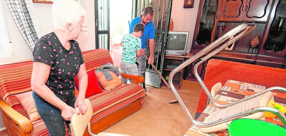 La familia Carrillo se esfuerza, hombro con hombro, por sacar el lodo que anega su casa de la huerta de Alquerías./Javier Carrión / AGM