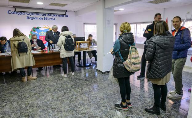 Varios colegiados se acercan a las mesas electorales para depositar su voto, este viernes. 