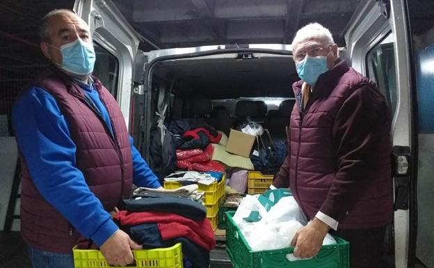 Dos voluntarios del dispositivo 'Ola de frío' de Cáritas reparten mantas y alimentos en Cartagena.