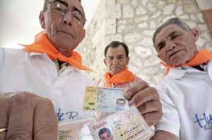 IDENTIDADES. Hieronides Moreno Benito (i), Filogonio Rica Herrero (c) y Marcelino García García (d) muestran el DNI, ayer, en la localidad burgalesa de Huerta de Rey. / EFE/