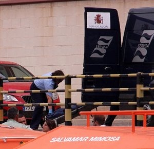 Una empleada del servicio funerario sube el cadáver al furgón judicial. / P. SÁNCHEZ / AGM/