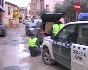 Dos agentes de la Guardia Civil de Murcia transportando documentación durante la operación :: G. CIVIL/