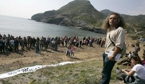 El portavoz de Anse, Pedro García, se sitúa ante parte de los manifestantes, tras llegar a la playa, para leer el manifiesto. :: JOSÉ MARÍA RODRÍGUEZ / AGM/