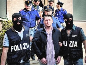 Momento de la detención de Nicola Schiavone, en su chalé-búnker, a las afueras de Casal di Principe. A la derecha, el asesinato de Mariano Bacio, un conocido miembro del crimen organizado en Nápoles. Lo cometió un sicario de la Camorra, a plena luz del día, y los transeúntes ni se inmutaron. ::
ROBERTO SALOMONE/AFP/
