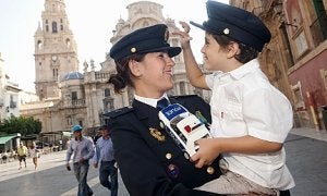 Una policía nacional bromea con un pequeño en la plaza Cardenal Belluga antes del acto. :: VICENTE VICÉNS/