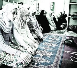 Mujeres arrodilladas en pleno rezo en la mezquita del barrio del Carmen de Murcia, donde se encuentra uno de los centros de culto más populares de la ciudad, que también es un lugar abierto al debate y la participación./