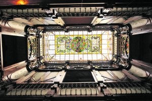 La galería de madera que hay sobre el vestíbulo de la Casa-Museo Modernista, coronada con una claraboya cubierta de una ornamentada vidriera./