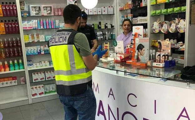 Un agente de la PolicÃ­a Nacional, en una de las farmacias atracadas este martes en Murcia./LV