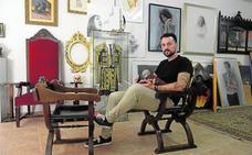 El artista Martínez Cánovas posa en su estudio de la ciudad de Murcia mientras hojea un libro de arte y toros./guillermo carrión / agm