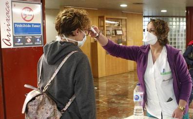 Una sanitaria toma la temperatura a una mujer en La Arrixaca./Martínez Bueso
