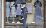 Un hombre, protegido con una mascarilla, se resguarda de la lluvia en Murcia, en una imagen de archivo./Javier Carrión / AGM
