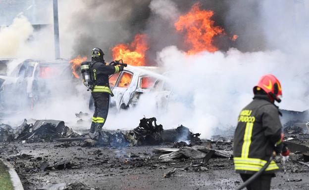 Firefighters put out the fire caused by the plane when it crashed in Milan.