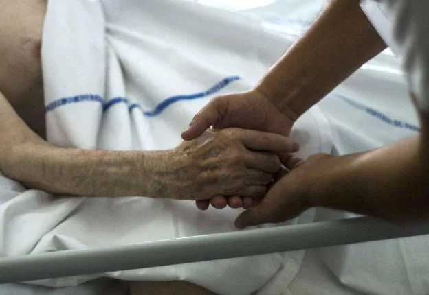 A medic tucks in a palliative care patient. 