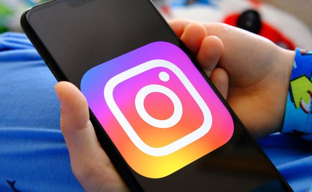 The Instagram logo appears on the screen of a mobile phone.