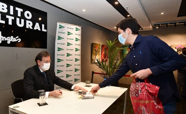Mariano Rajoy signs one of the copies to a young man, yesterday, in Murcia. 