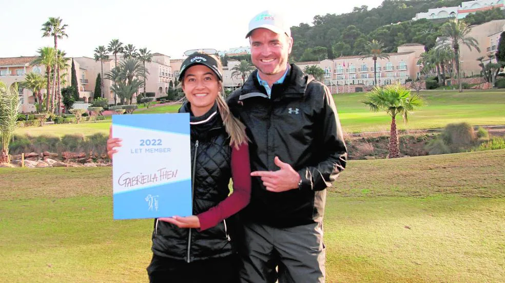A good tandem.  The champion Gabriella Then and Alex McIver, acting as the player's cadi, posing smiling at the end of the competition, in the vicinity of the clubhouse. 