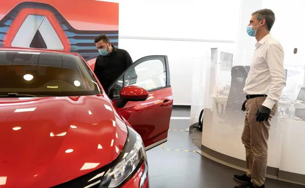 A buyer examines a vehicle at a dealership, in a stock photo.