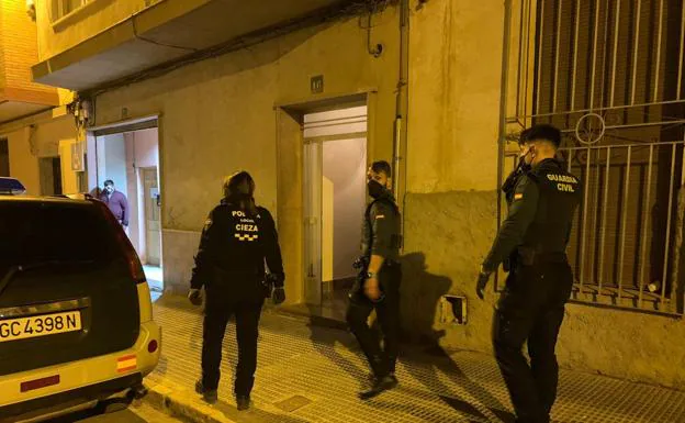 Police officers and Civil Guard, in front of the house.