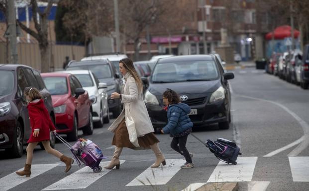 A woman and two children cross Jacinto Benavente, on their way to a school. 