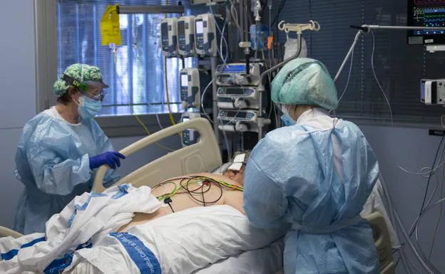 Two health workers attend to a patient in the ICU of the Girona hospital.