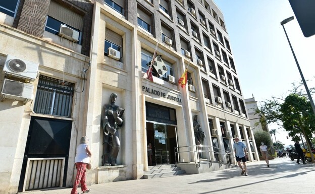 Citizens walking in front of the headquarters of the Provincial Court, in Murcia. 