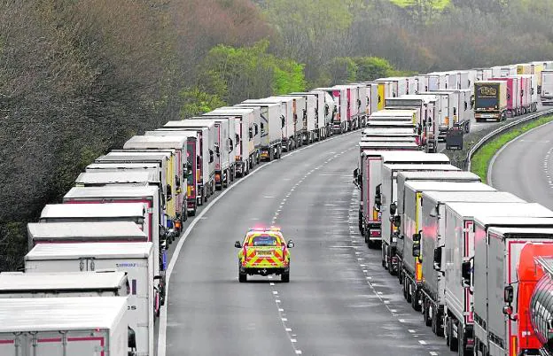 An emergency vehicle passes between the queues of lorries at the approaches to the port of Dover. 