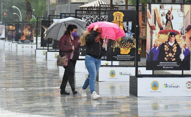 Two people protect themselves from the rain, in a file image.