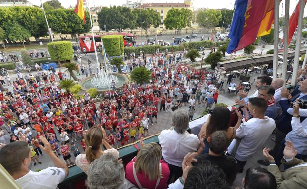 Los aficionados presentes en La Glorieta cantan y agitan sus bufandas, con jugadores, ténicos, directivos y políticos en el balcón. 