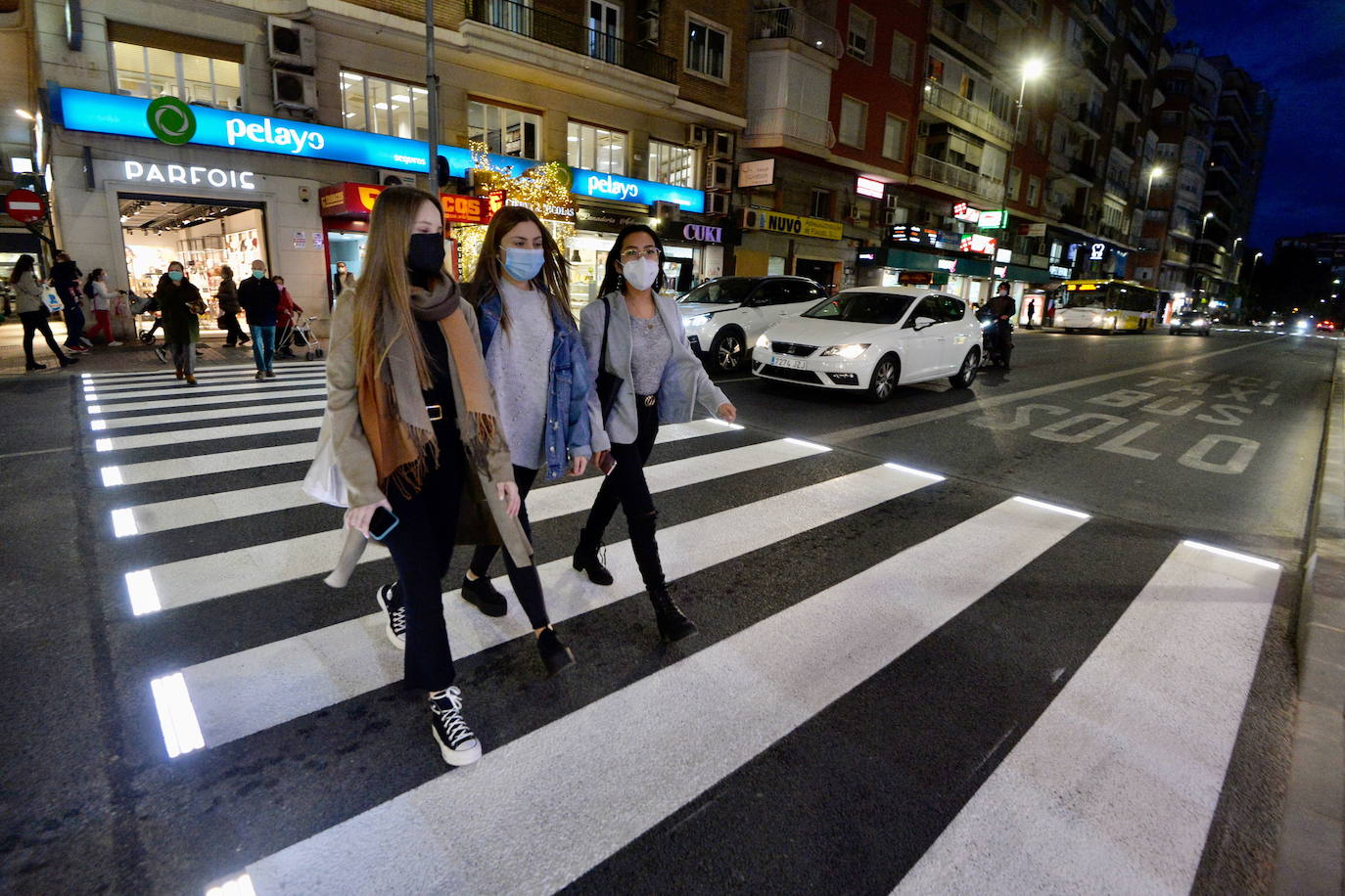 Three girls crossing a zebra crossing.