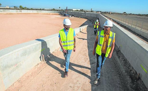 Technicians from the Arpo company walk along the access ramp to the enormous pool built next to the Torre Pacheco treatment plant.