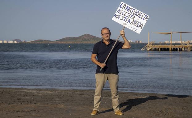 Juan Antonio Ortega, in Los Urrutias, with a poster made by his daughter Paola for the Mar Menor demonstration. 