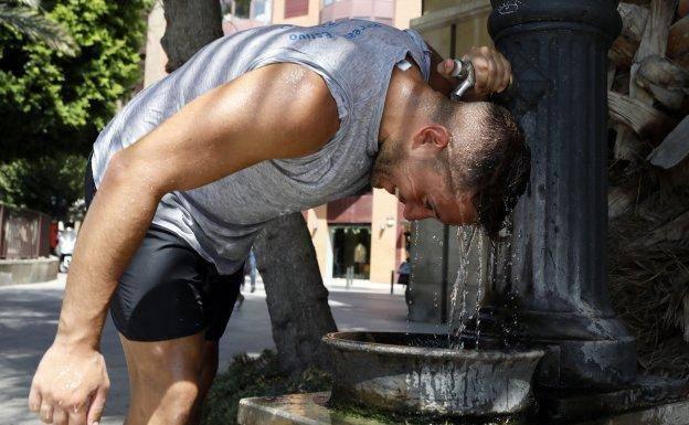 A man pours water into a fountain to fight the heat in Murcia, in a file image.
